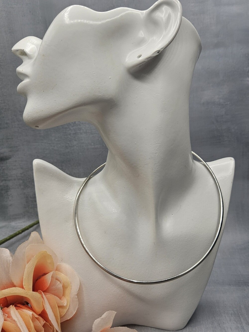 Minimalist silver torque collar necklace often referred to as an open neck wire